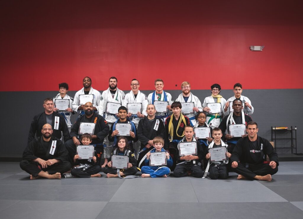 Group of martial arts students and instructors posing with certificates