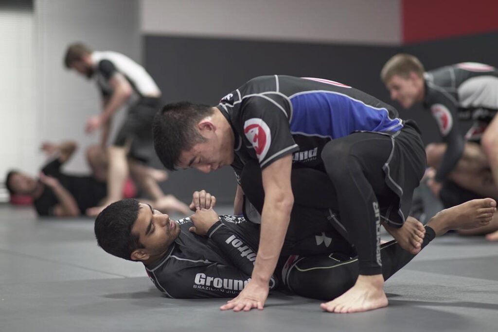 Two Brazilian jiu-jitsu students in the midst of grappling on the ground