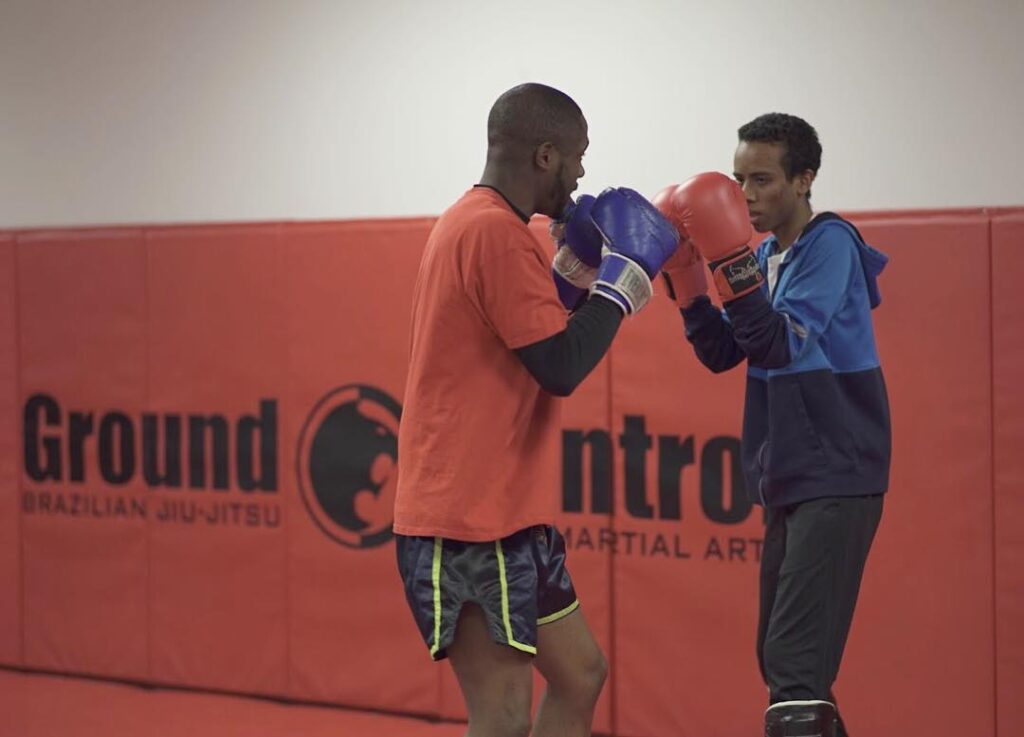 Two martial arts students sparring with punching gloves
