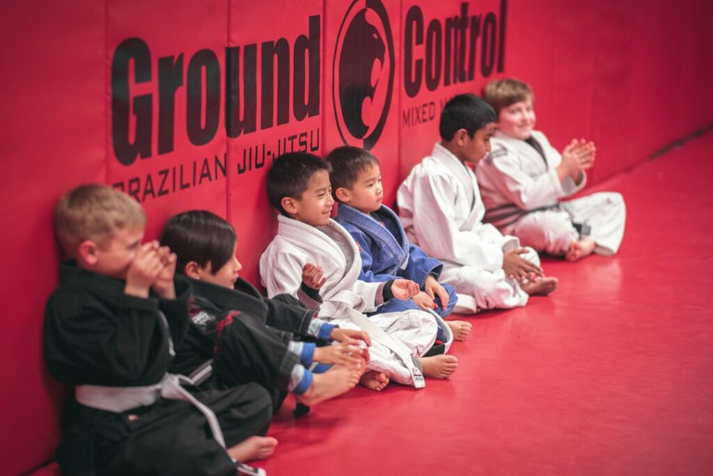 Kids sitting against the wall in a martial arts class