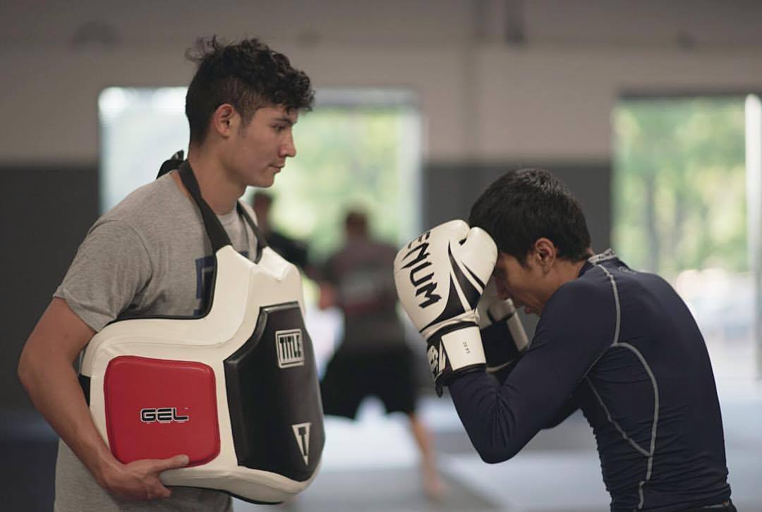 Man practicing punching with trainer