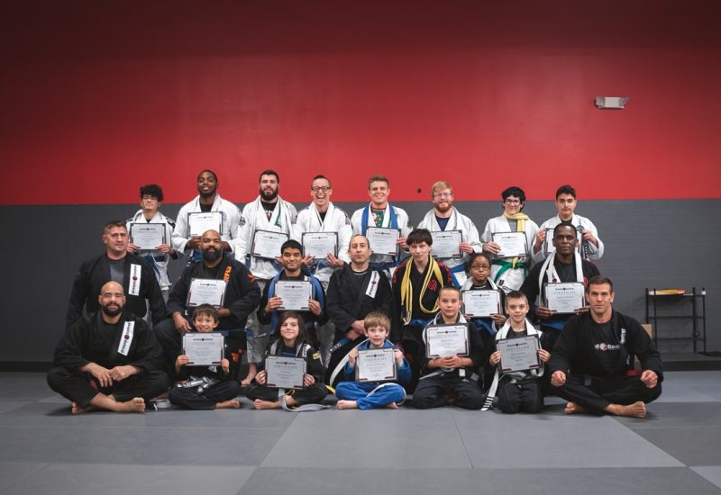 Group of martial arts students and instructors posing with certificates